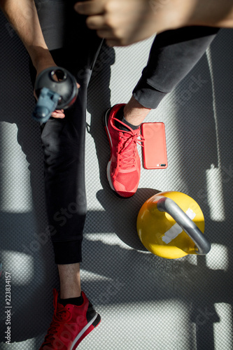 Male athlete preparing for workout with kettlebells in gym. Male athlete getting ready for training. Sportboots and active lifestyle concept. Close-up photo