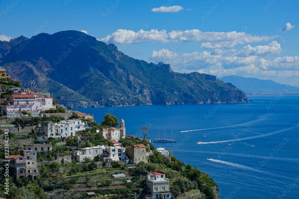 Fototapeta premium AERIAL: Flying towards beautiful coastal village on a hill in the Mediterranean.