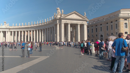 Tourists wait in line to see a famous Italian catholic cathedral on a sunny day.
