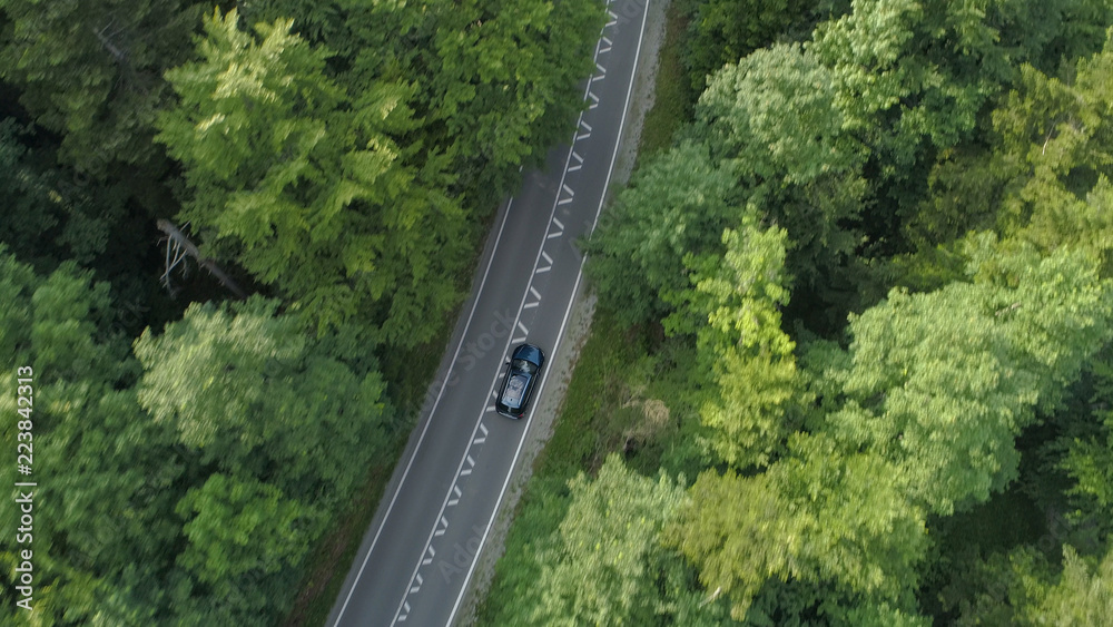 AERIAL Tourists on fun road trip enjoying driving through the scenic countryside