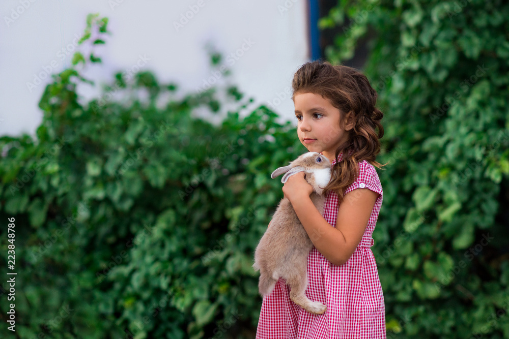 Girl is holding a cute little rabbit, outdoor shoot Girl is holding a cute little rabbit, outdoor shoot