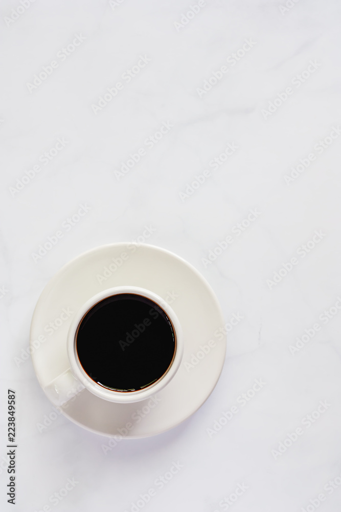 Cup of black coffee with saucer on white marble background for drinks and beverage concept (Vertical image) Cup of black coffee with saucer on white marble background for drinks and beverage concept (Vertical image)