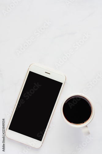 Smartphone with cup of blac...