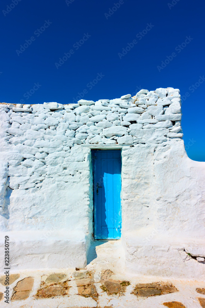 Naklejka premium Narrow door in ancient whitewashed wall