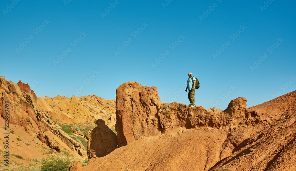 caucasian man with  backpacks hiking to top of mountain