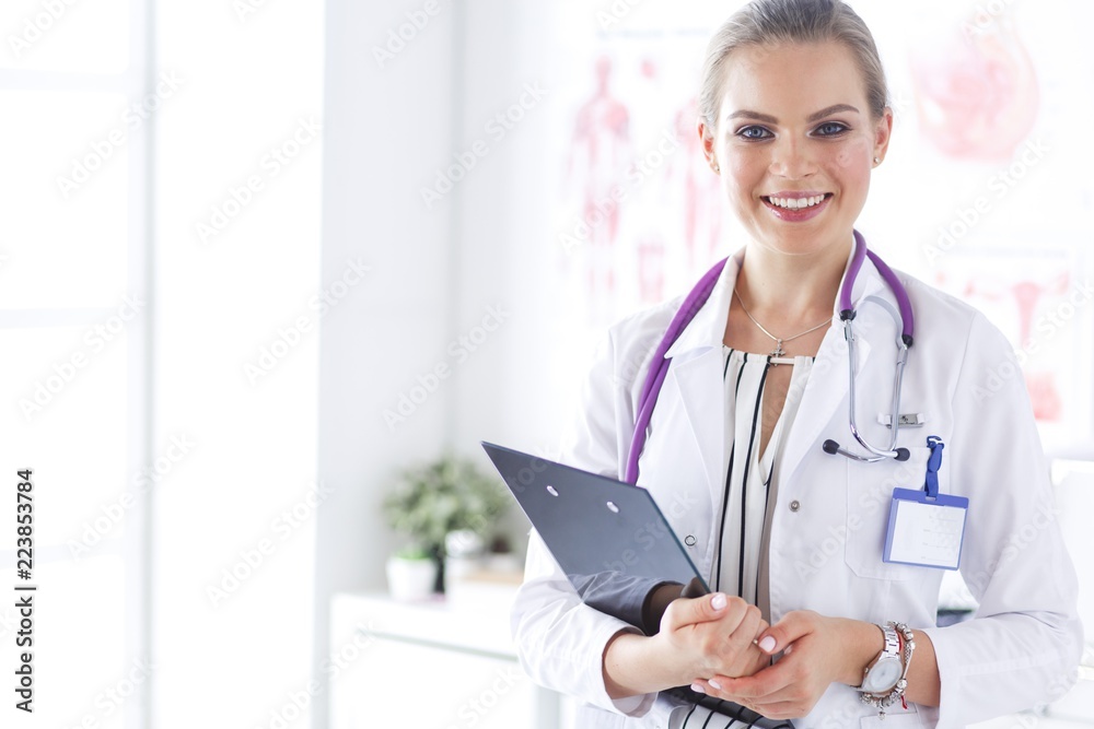 Smiling female doctor with a folder in uniform standing Smiling female doctor with a folder in uniform standing