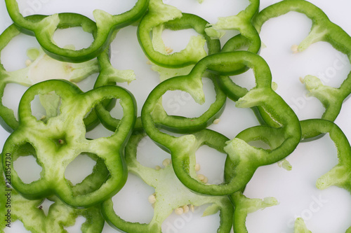 Slices of Bell pepper on white paper for background.