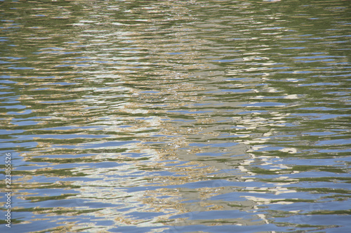 drobne fale na rzece z odbiciami promieni słonecznych