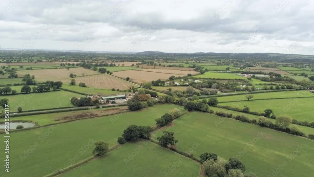 Aerial view, pedestal rise move and zoom in. Plains, grass, pond in Cheshire. Cars on road in background Aerial view, pedestal rise move and zoom in. Plains, grass, pond in Cheshire. Cars on road in background
