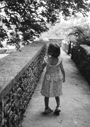 Niña de espaldas en un puente