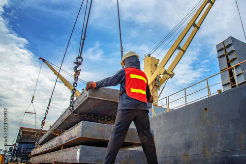 bundle of steel slab being loading discharging in port terminal, handle by gang of stevedore labor , shipment cargo in transition from land and sea transport services