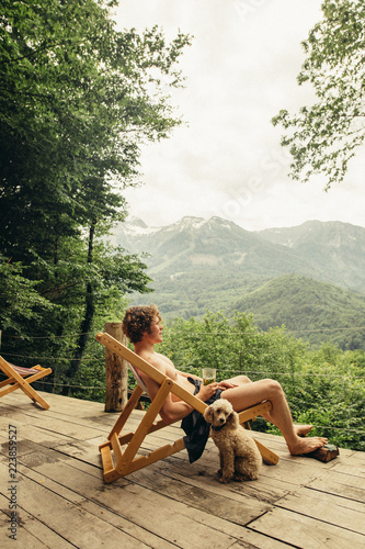 handsome tourist sitting on a launge and enjoying the beauty of amazing landscape. foggy mountains and forest on the background of the photo.vacation and rest concept. side view full length photo photo