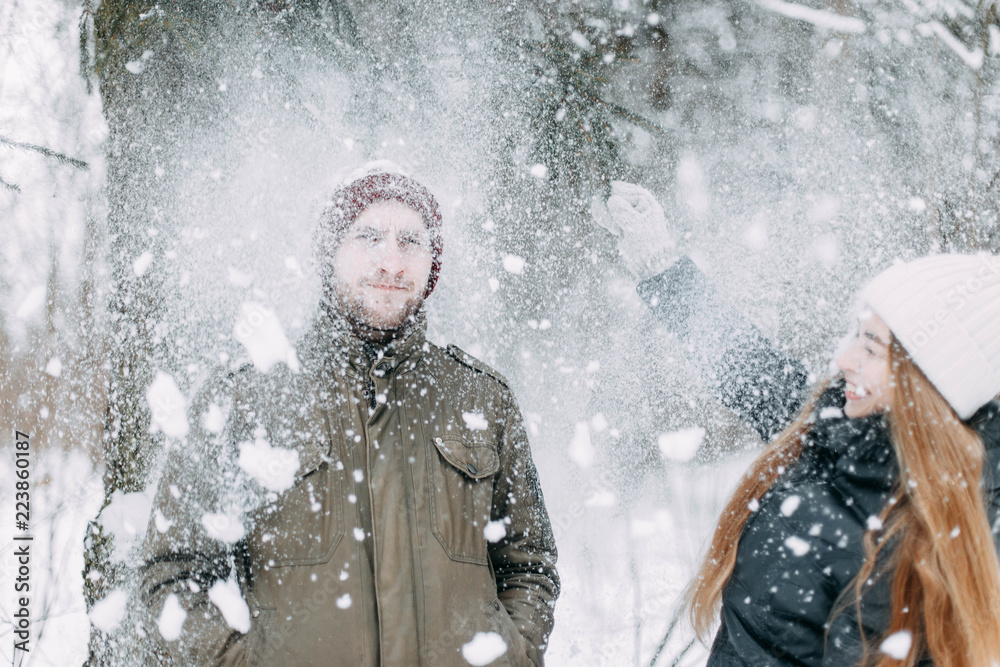 happy young people, couple in winter snowy forest. beautiful lovers having fun. happy young people, couple in winter snowy forest. beautiful lovers having fun.