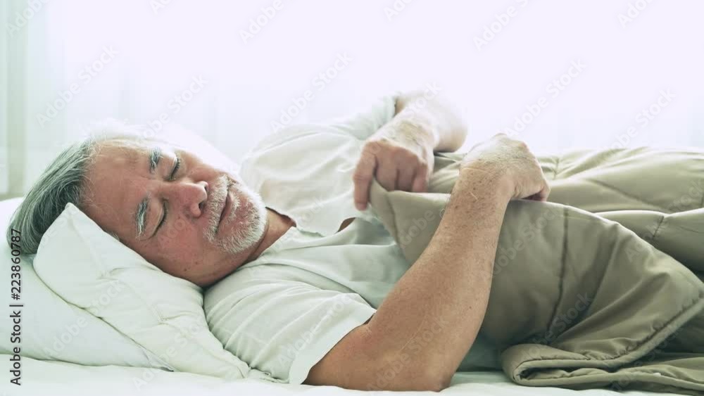 Senior man sleeping in bed. Old asian man sleeping comfortably in bed with curtain open. Senior lifesyle concept. Close up shot.
