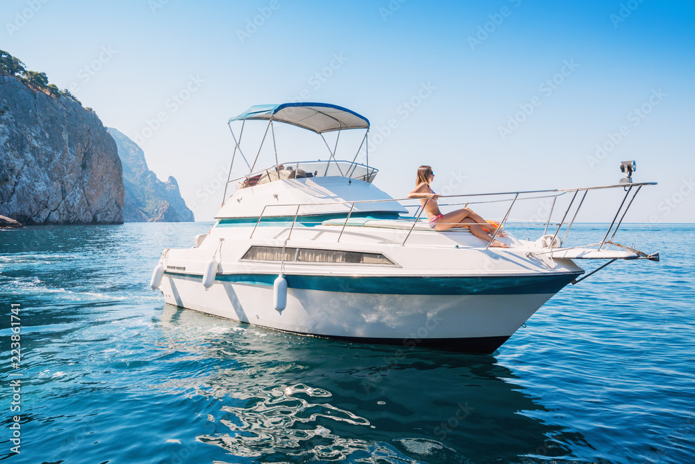 Beautiful woman relaxes on a private yacht in the sea near the islands.