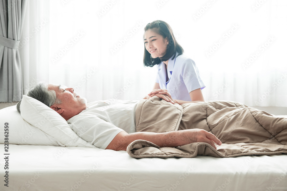 Senior man in bed and nurse woke him up.