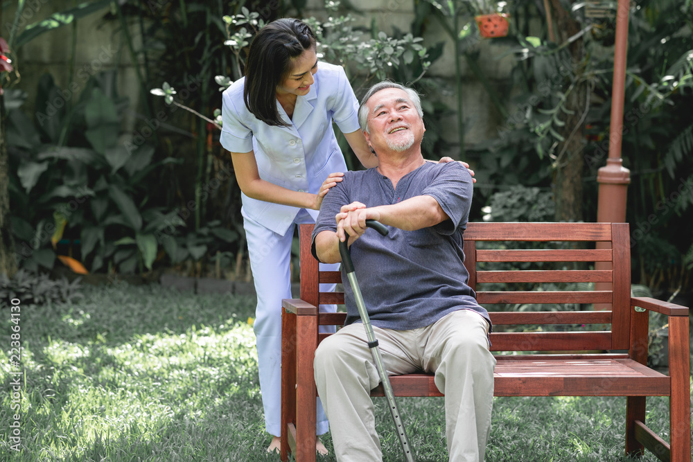 Nurse with patient sitting on bench together.