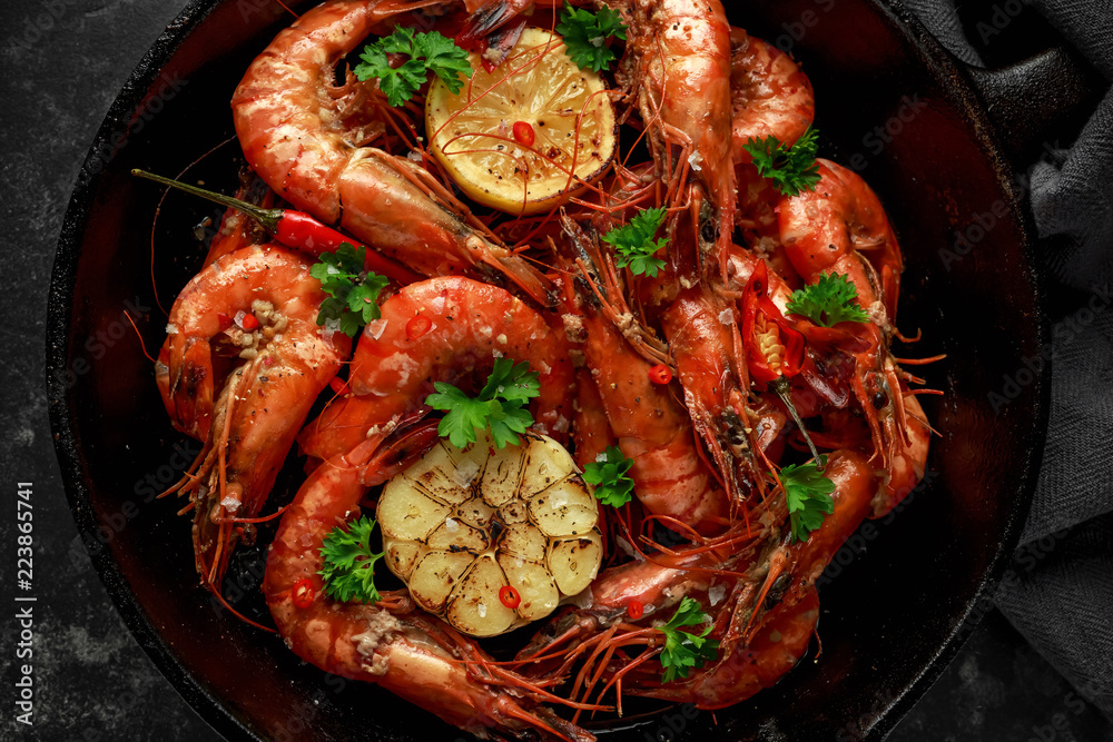 Tiger prawns fried in butter with, lemon juice, garlic and white wine served in cast iron skillet with parsley Tiger prawns fried in butter with, lemon juice, garlic and white wine served in cast iron skillet with parsley