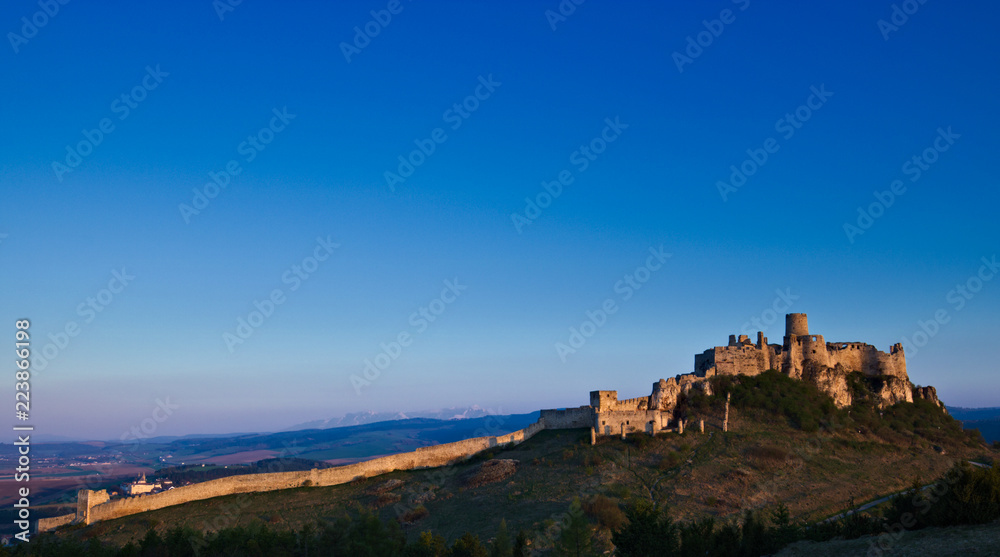 A southeastern view of the Spis castle in the morning in early spring with clear sky and the Tatra mountains in the background