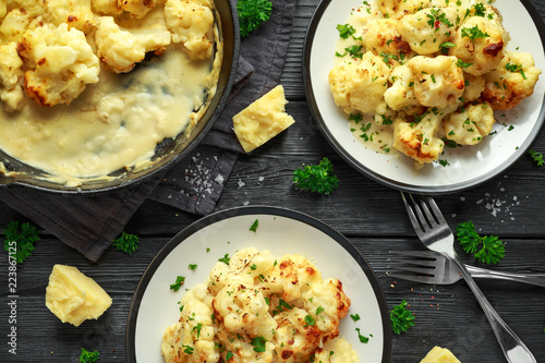 Roasted cauliflower with cheddar cheese sauce and herbs. photo