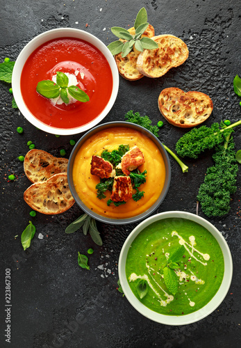 Variety of cream soup bowls: sweet pea and mint, tomato and basil and butternut squash with steamed kale and fried halluomi