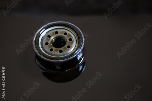 Used oil filter stands in old oil. The process of replacing the engine oil in a car