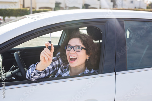 happy woman driver hold car keys in her new car