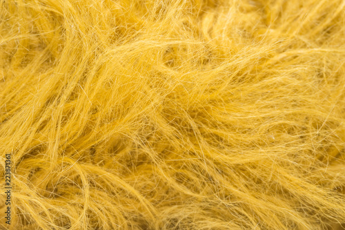 Yellow soft natural animal wool texture background. Skin wool. Close-up texture of white fluffy fur. Red plush