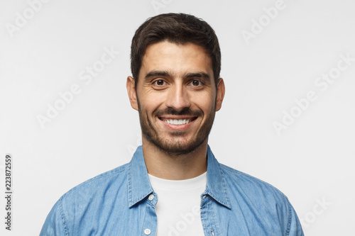 Tableau sur toile Smiling handsome man in blue shirt isolated on gray background