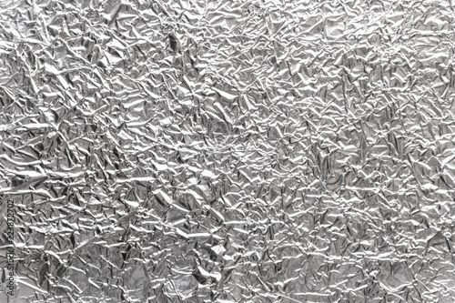 Silver wrinkled food foil background texture, crumpled aluminum foil, abstract shiny background