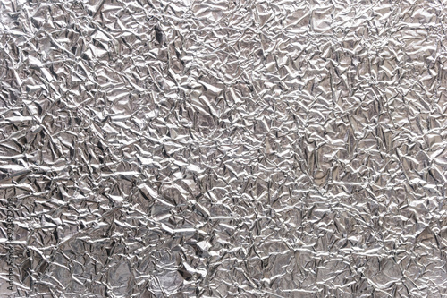Silver wrinkled food foil background texture, crumpled aluminum foil, abstract shiny background