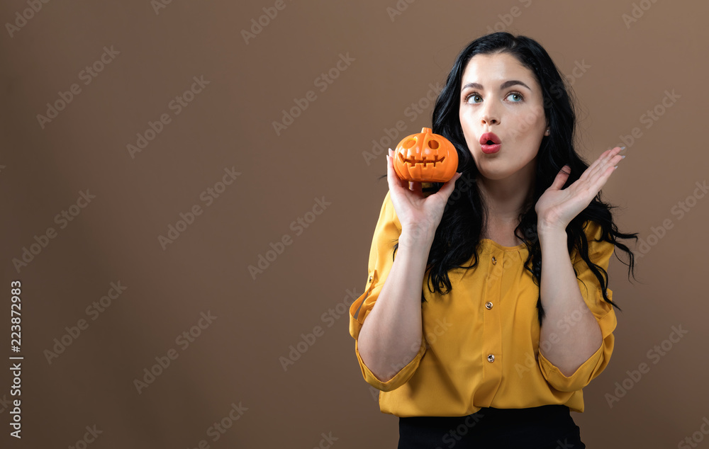 Young woman holding a pumpkin for halloween Young woman holding a pumpkin for halloween