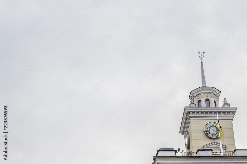 Ukrainian city hall high tower with national coat of arms on gray sky in rainy day time empty space for your text Ukrainian city hall high tower with national coat of arms on gray sky in rainy day time empty space for your text