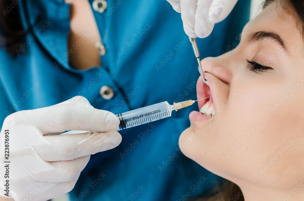 Dentist giving anesthesia to client Dentist giving anesthesia to client
