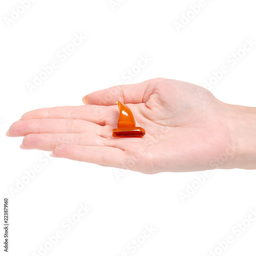 Amber stone brooch in hand on a white background isolation