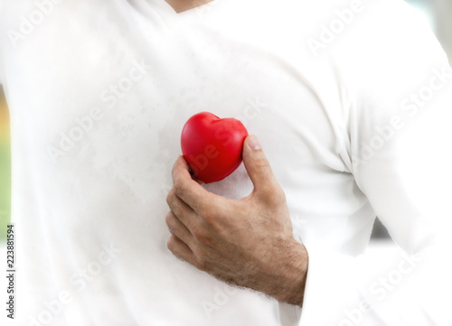Fototapeta Naklejka Na Ścianę i Meble -  man hand holding plush a red heart at left his chest ,Valentine day concept ,Love heart, protect and healthcare