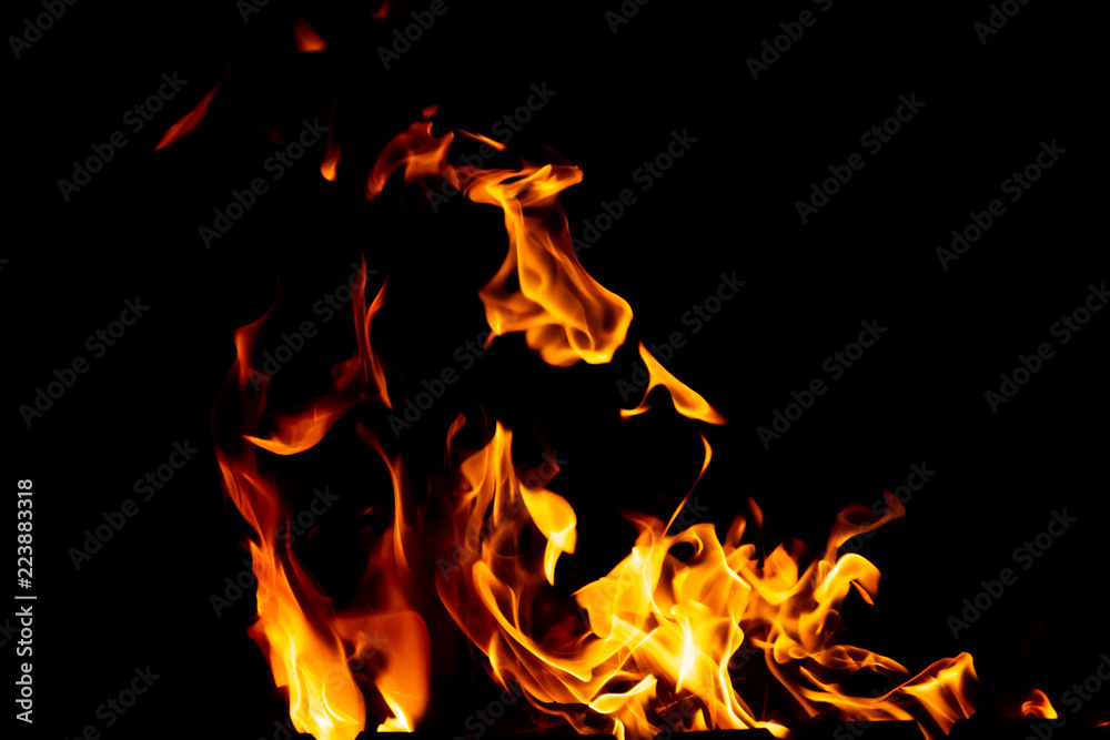 Flames of fire from burning coals in the grill late at night.