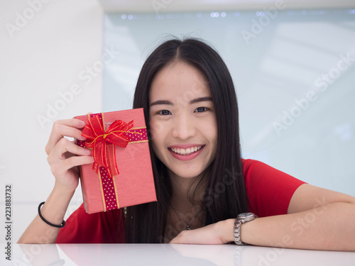 Portrait of a young woman with a red giftbox