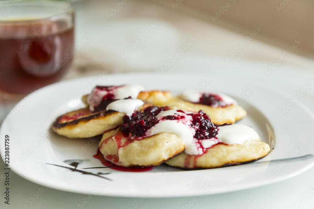 Pancakes with lingonberry cream sauce on a plate