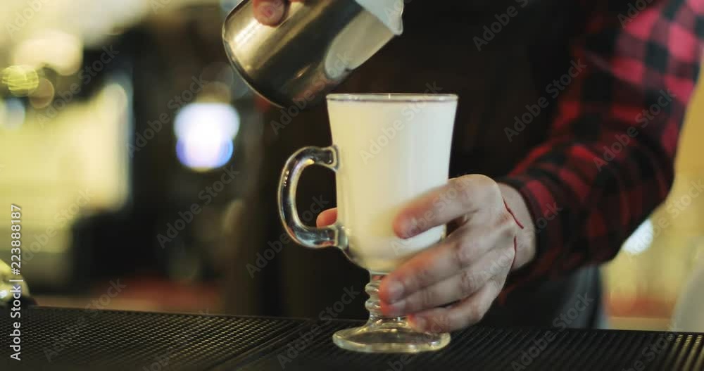 The barman is making cappuccino. The barman is making cappuccino.