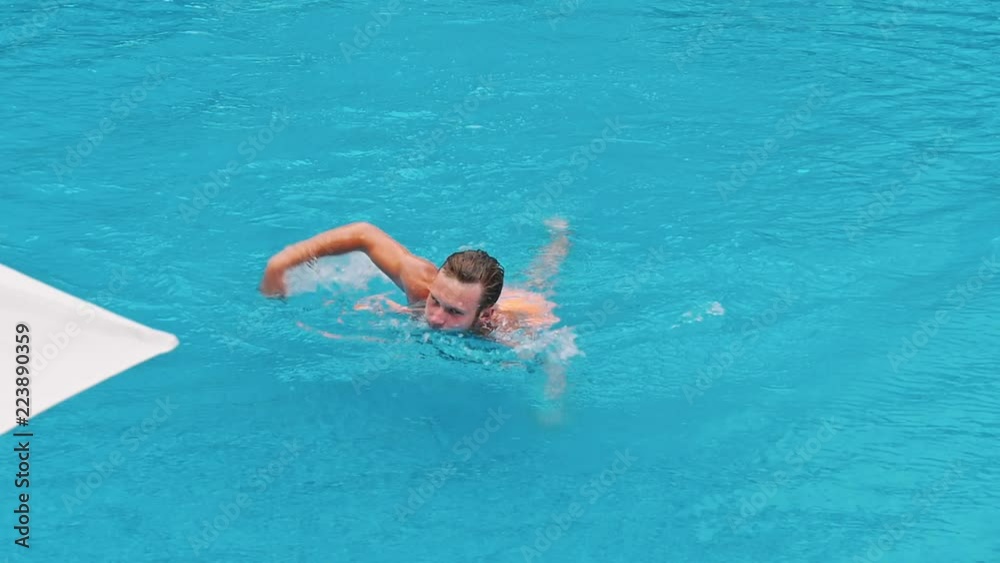 Young guy swims underwater in a swimming pool Young guy swims underwater in a swimming pool
