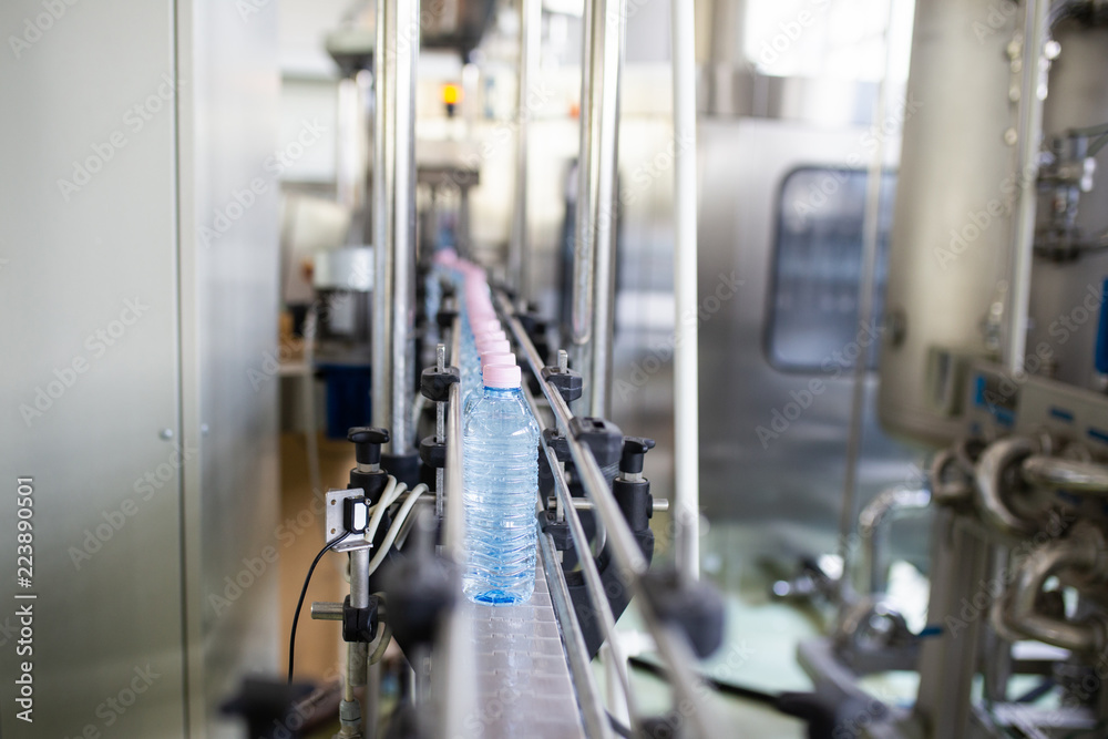 Bottling plant - Water bottling line for processing and bottling carbonated water into bottles. Selective focus. Bottling plant - Water bottling line for processing and bottling carbonated water into bottles. Selective focus.