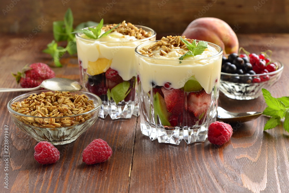 Dessert with fresh berries, granola and custard in glasses Dessert with fresh berries, granola and custard in glasses