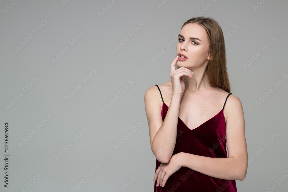 Blond girl in red dress poses showing emotions: dreaminess, muse Blond girl in red dress poses showing emotions: dreaminess, muse
