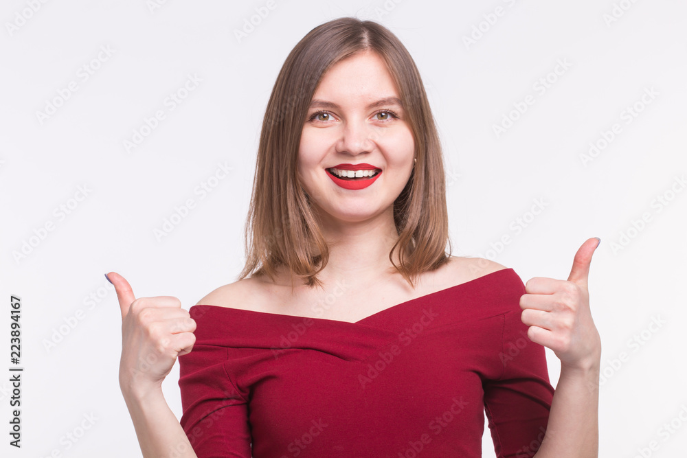 Portrait of happy girl with red lips and thumbs up on white background Portrait of happy girl with red lips and thumbs up on white background