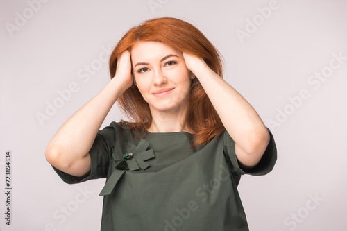 Fashion and people concept - young woman hide ran her hands in red head and smile