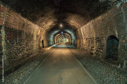 Walking through the Headstone Tunnel, near Monsal Head in the East Midlands, Derbyshire, Peak District, England, UK