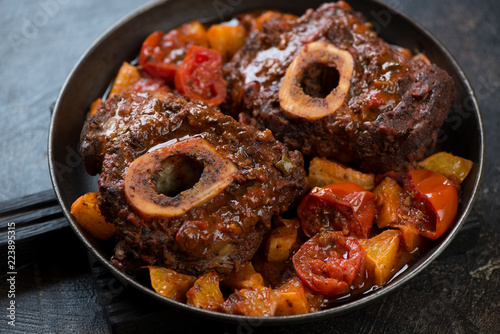 Closeup of osso buco made of cross cut veal shank with addition of stewed oranges and tomatoes, horizontal shot