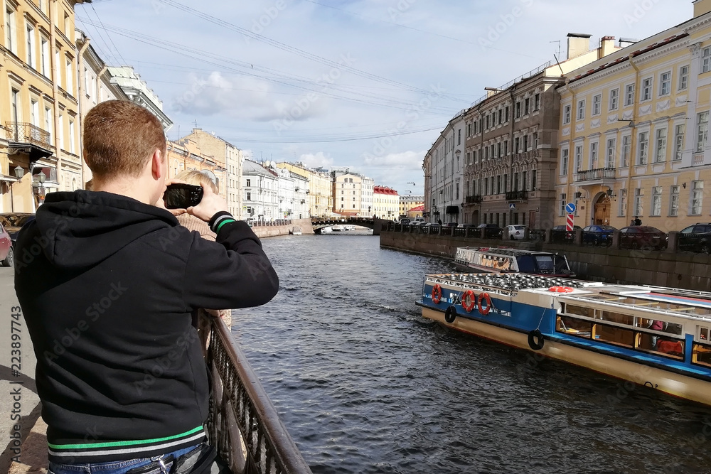 tourist takes pictures of the river embankment in the city