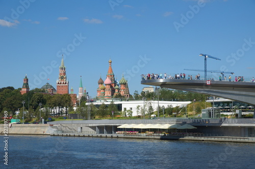 Moscow, Russia - August 24, 2018: Soaring bridge on the background of the Kremlin and St. Basil's Cathedral in Zaryadye natural landscape Park  © koromelena
